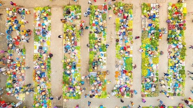 An overhead shot of a diverse group of people painting a large street mural together on a sunny day, with children and adults all contributing, embodying the spirit of community co-creation in public art.