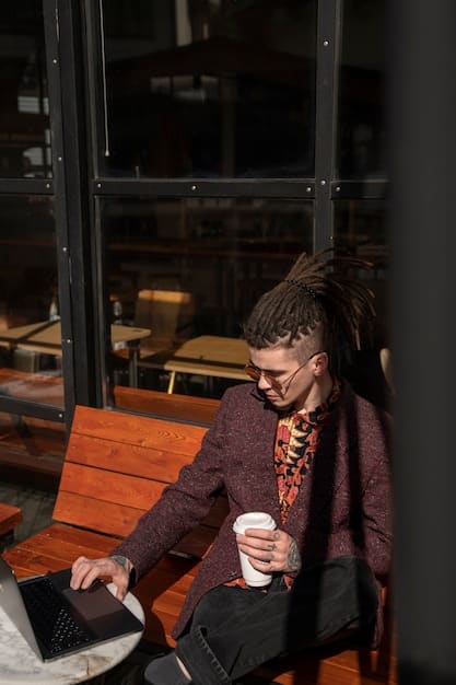 A person working on a laptop in a coffee shop, with a relaxed and focused expression. The image represents the flexibility and independence associated with gig work.