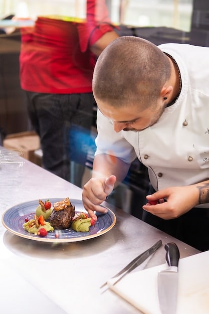 A chef preparing a fusion dish in a modern, open-concept kitchen, focusing on the blend of different cultural ingredients.