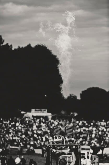 A black and white photo of Jimi Hendrix performing at the Monterey Pop Festival in 1967, setting his guitar on fire, surrounded by a rapturous crowd.
