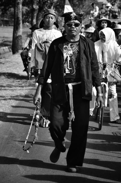 A black and white photo from the 1950s showing African American students being escorted into a previously all-white school by federal marshals. The image represents the historical struggle for desegregation.