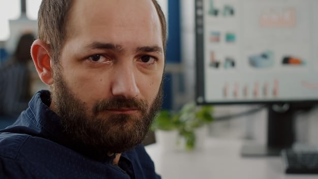 A close-up, professional shot of a concerned employee looking thoughtfully at their computer screen in an office setting. The lighting should be subtle, and the background slightly blurred to emphasize the employee's expression.