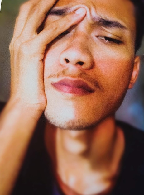 A close-up of a person's face, with a mix of anxiety and exhaustion evident in their eyes. The background should be blurred but suggestive of a professional setting, such as an office or a meeting room. The overall impression should be the psychological toll of navigating a workplace where racial bias is present.