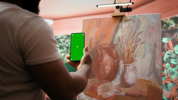 An artist using their phone to film a time-lapse video of themselves creating a painting. The lighting is natural, and the focus is on their hands and the artwork in progress.